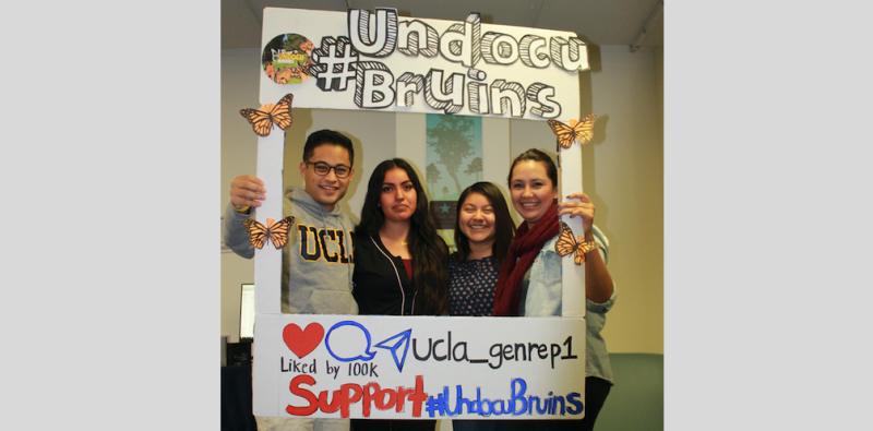 4 students posing in a large paper Instagram frame